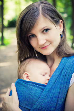 Frau mit Baby in der Wickelkreuztrage